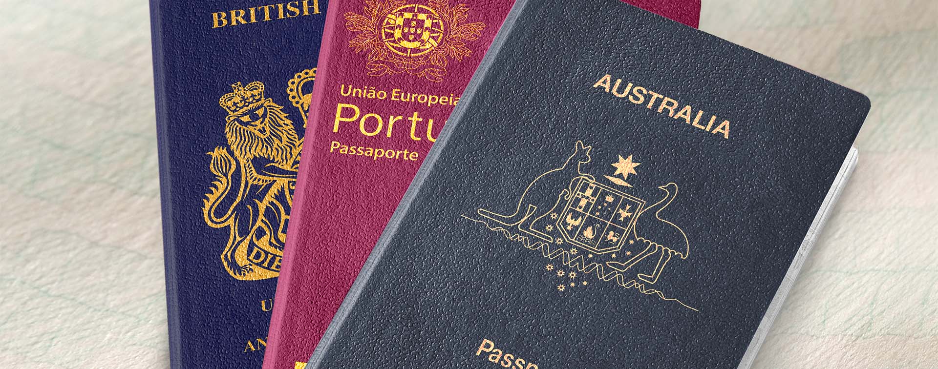Australian, Portuguese, and British passports fanned out on top of one another