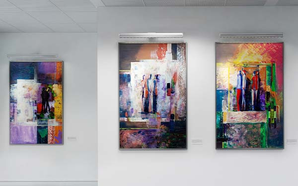 Four paintings hung on a gallery wall