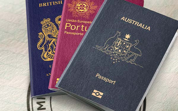 Australian, Portuguese, and British passports fanned out on top of one another