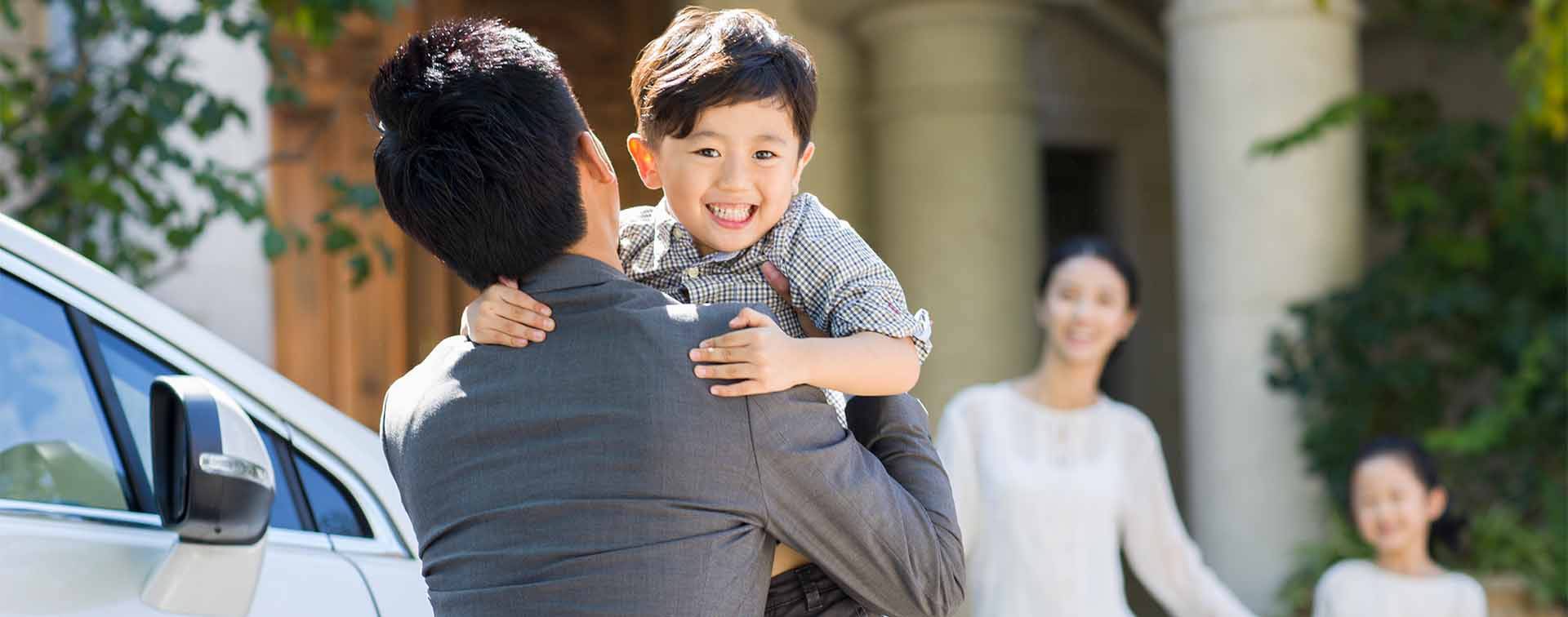 Businessman greeting his wife and children