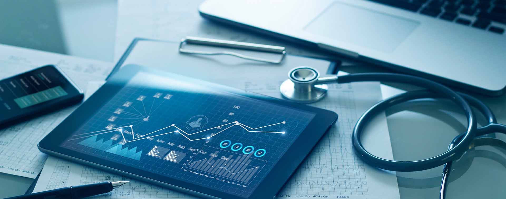 A desk with medical charts, a tablet, and a stethoscope