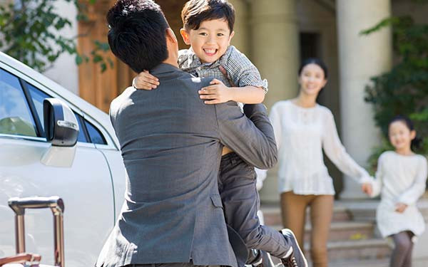 Businessman greeting his wife and children