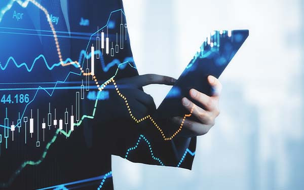 Trading and investment concept trader silhouette with digital tablet and virtual screen with financial chart graphs and candlestick