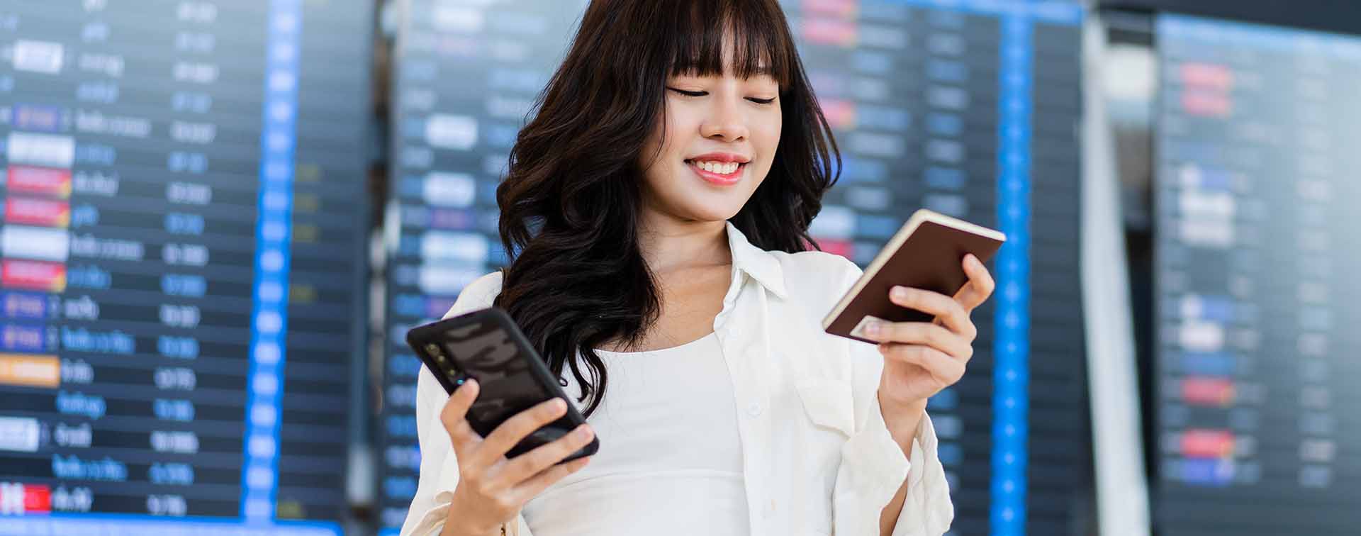 Woman holding passport and phone at airport