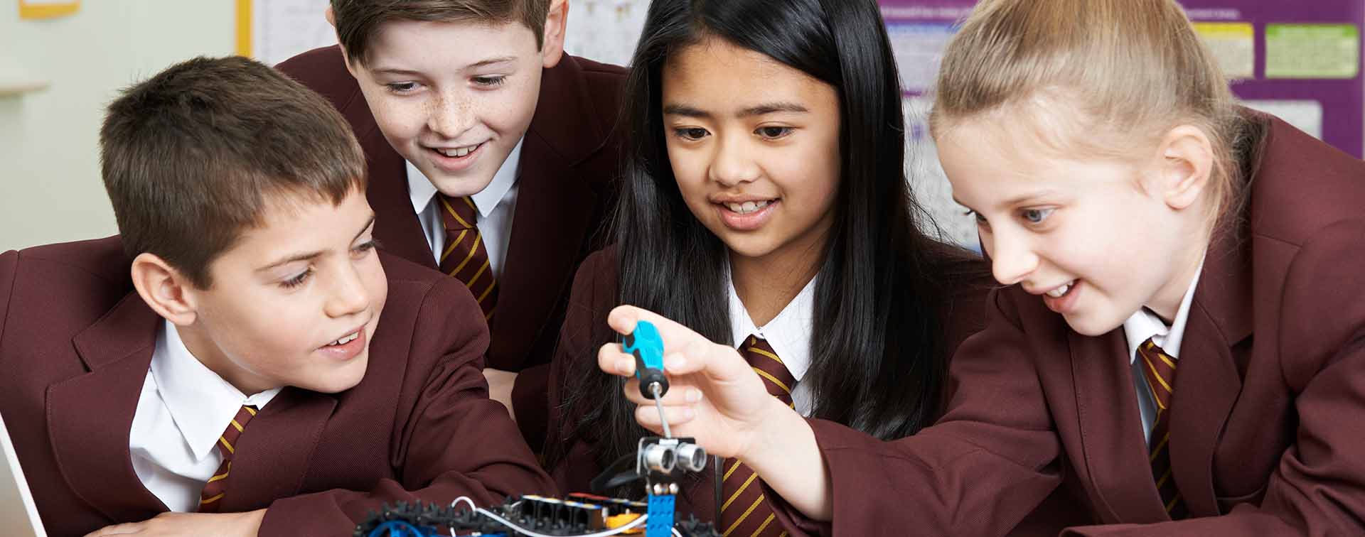School children building a robot in classroom