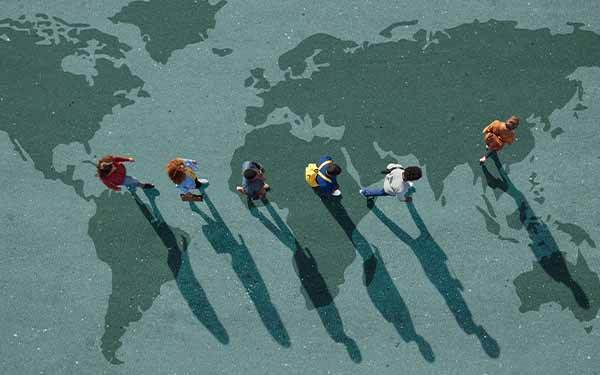 Diverse group standing on world map illustration representing global mobility