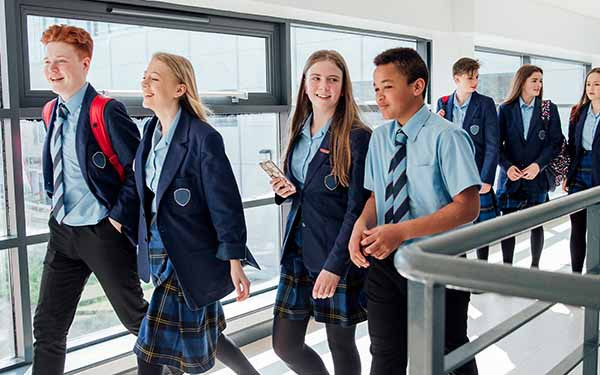 Students in school uniforms walking together in a hallway