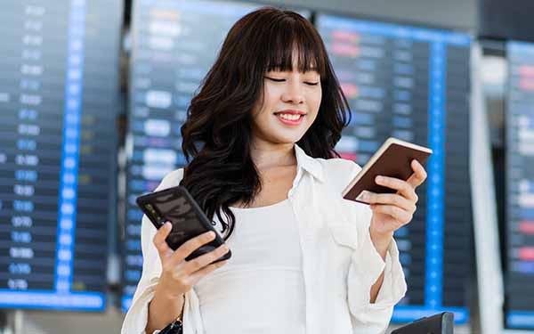 Woman holding passport and phone at airport
