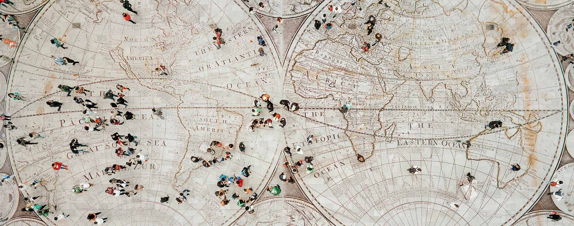 Aerial view of people walking over a floor with a world map design.