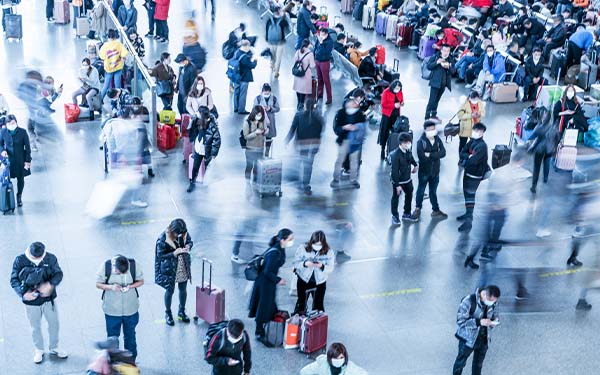 Top-down view of people in blurry movement or waiting in an aiport with luggage.
