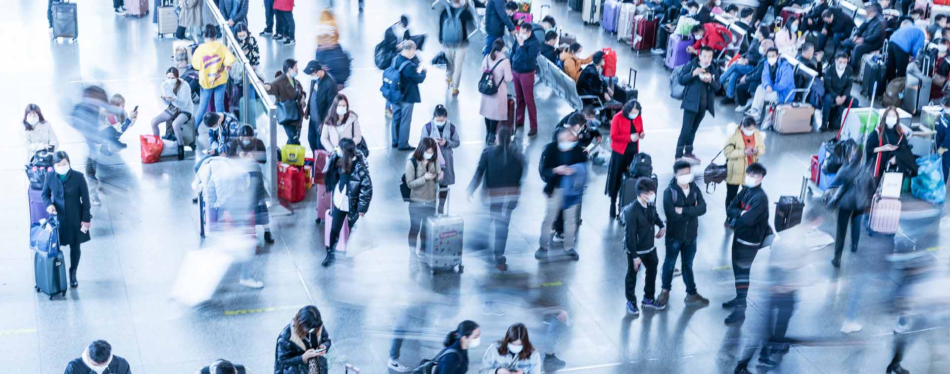 Top-down view of people in blurry movement or waiting in an aiport with luggage.