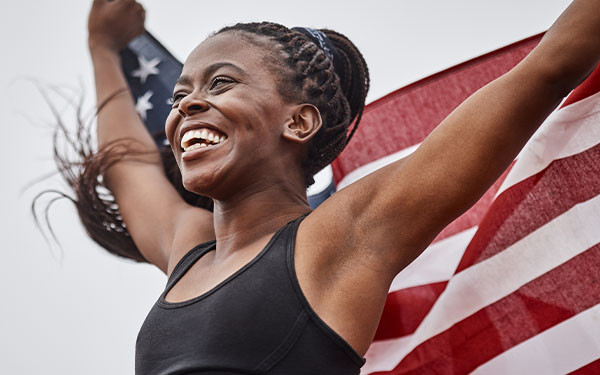 Female athlete holding up the flag of the United States of America
