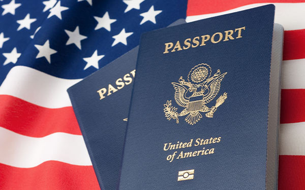 United States of America passport in front of the American flag