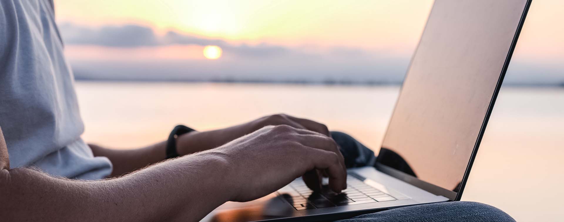 Man working on laptop in front of ocean view