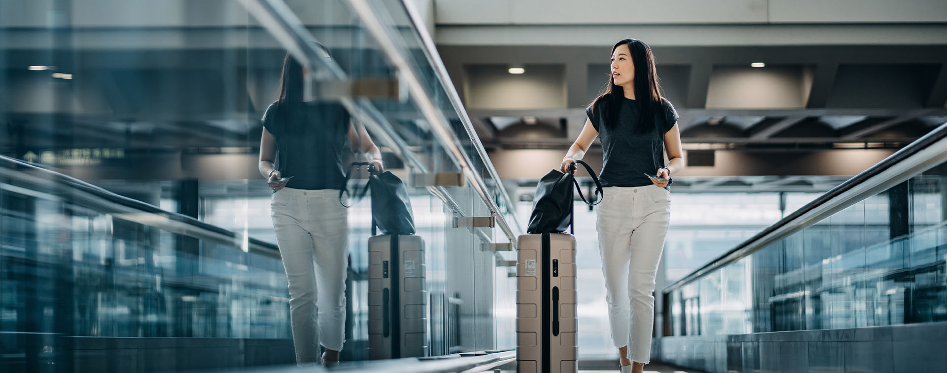 Woman with luggage walking through an airport terminal