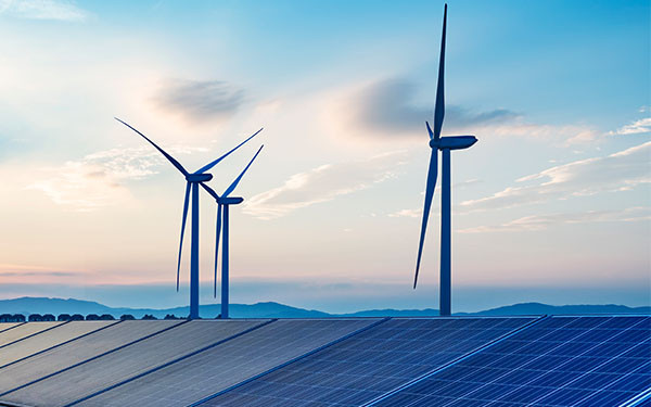 Wind turbines and solar panels under a blue sky