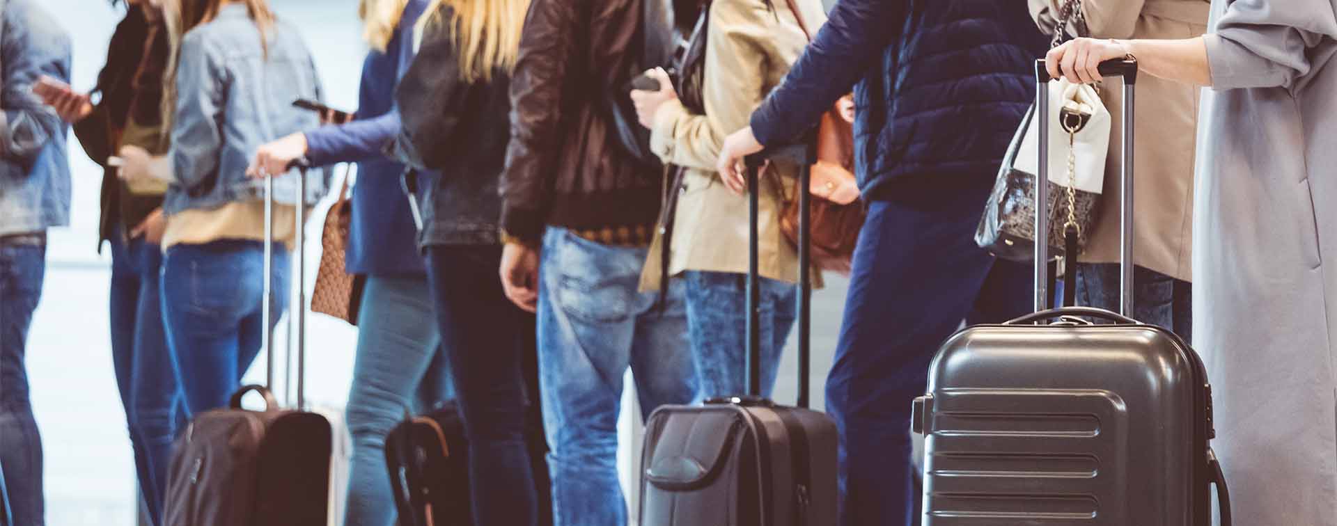 Queue of passengers waiting at boarding gate at airport.