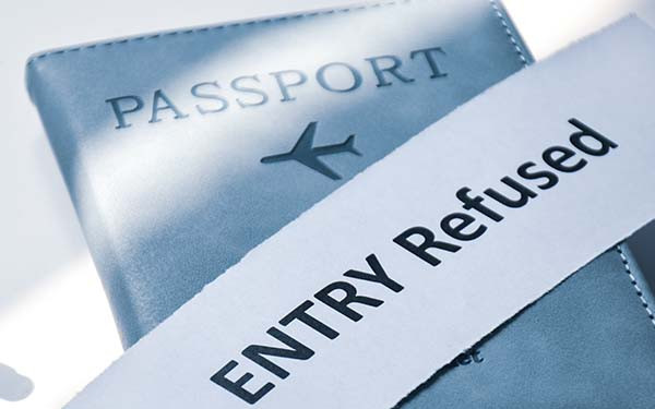 Torn paper with the inscription Entry refused on Passport.