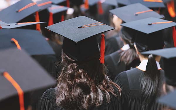Backside graduation hats during commencement success graduates of the university