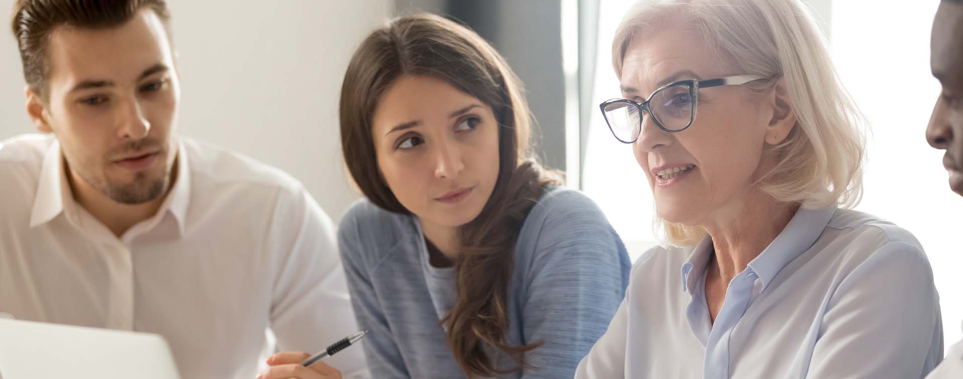 Focused young interns making notes listening to manager