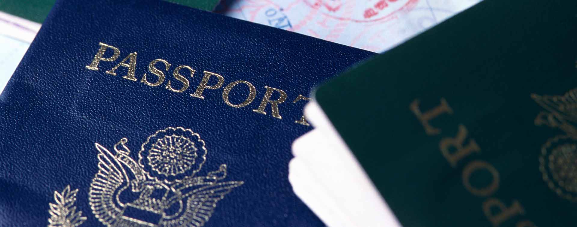 American passports, green, blue, black on open page with visa stamps