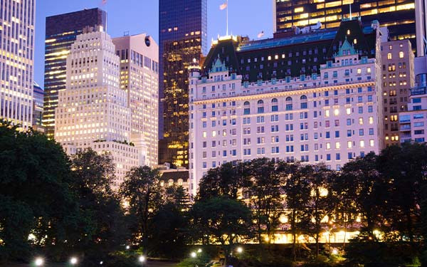 Plaza Hotel and other buildings as seen from Central Park in New York City, USA, lit up in the evening